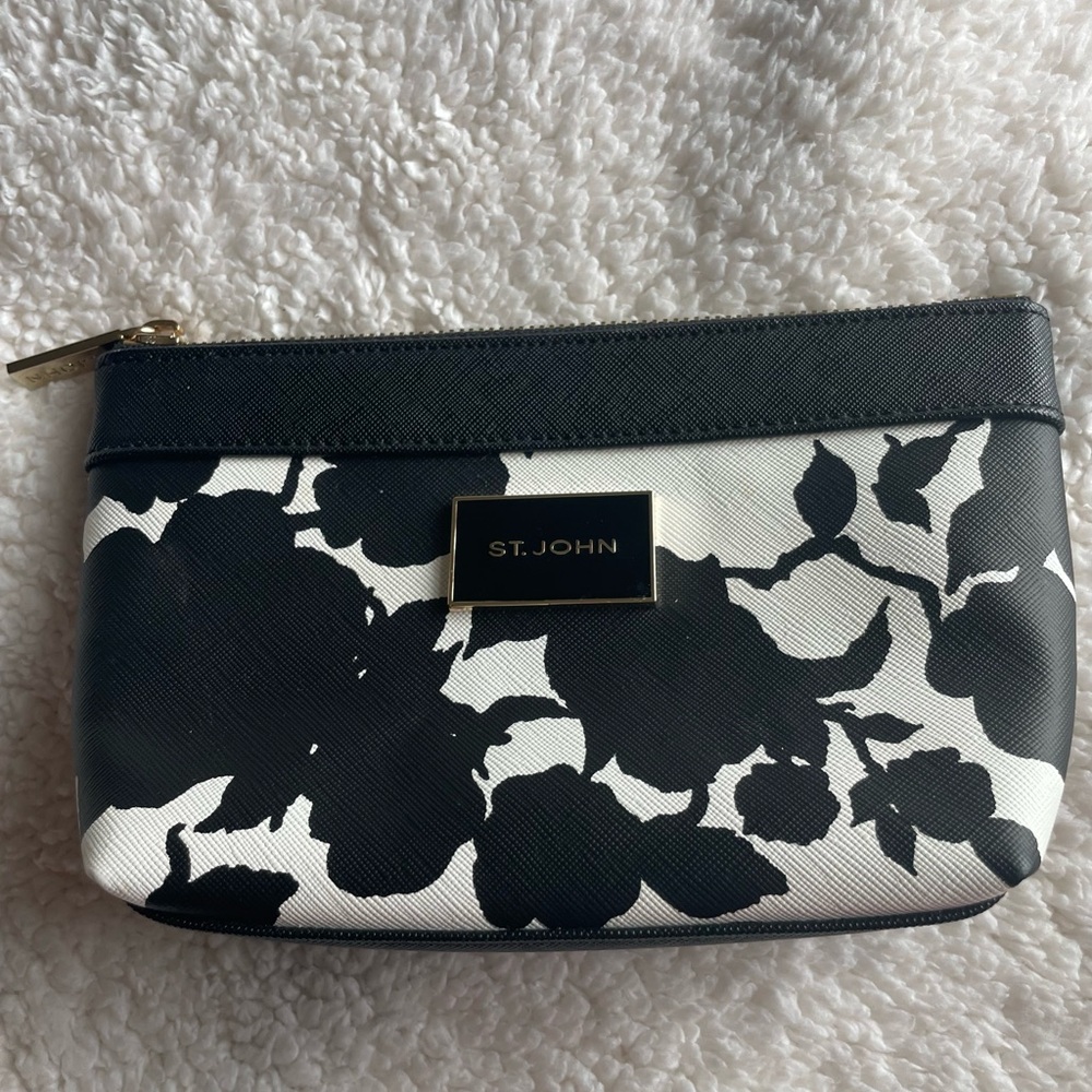 ST.JOHN black and white cosmetic bag with gold toned zipper and ST. JOHN emblem.